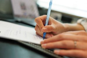 Writing in a notebook while working on an employer branding strategy at JKC Media