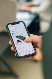 Phone in hand with LinkedIn open, social media content calendar 2025 by JKC