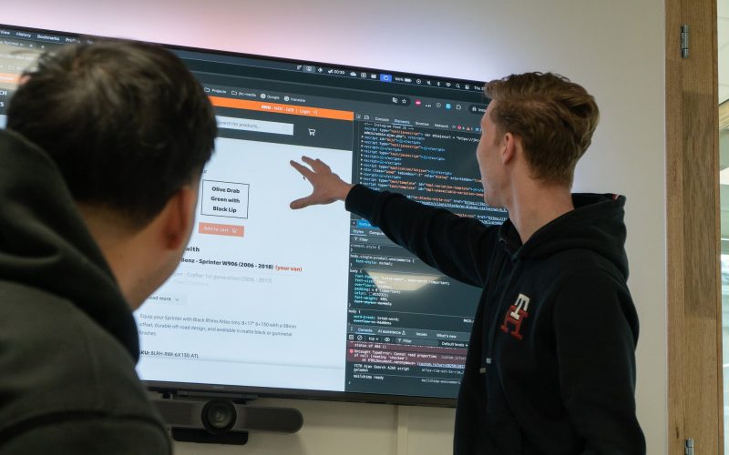 A JKC Media colleague explaining a website to another colleague on a TV screen