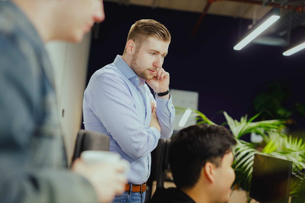 Two colleagues talking through a plan, coffee in hand