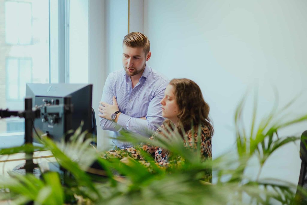 Two colleagues reviewing a social campaign together at a screen