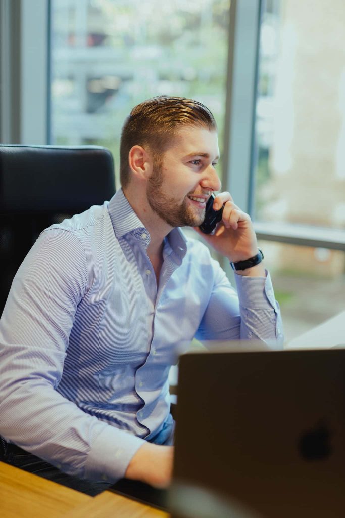 A colleague on the phone at a desk by the window