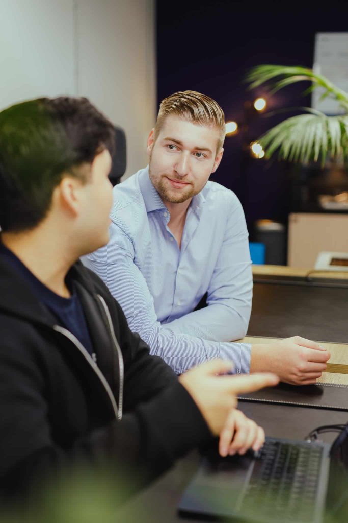 Two colleagues discussing the next improvement at a desk