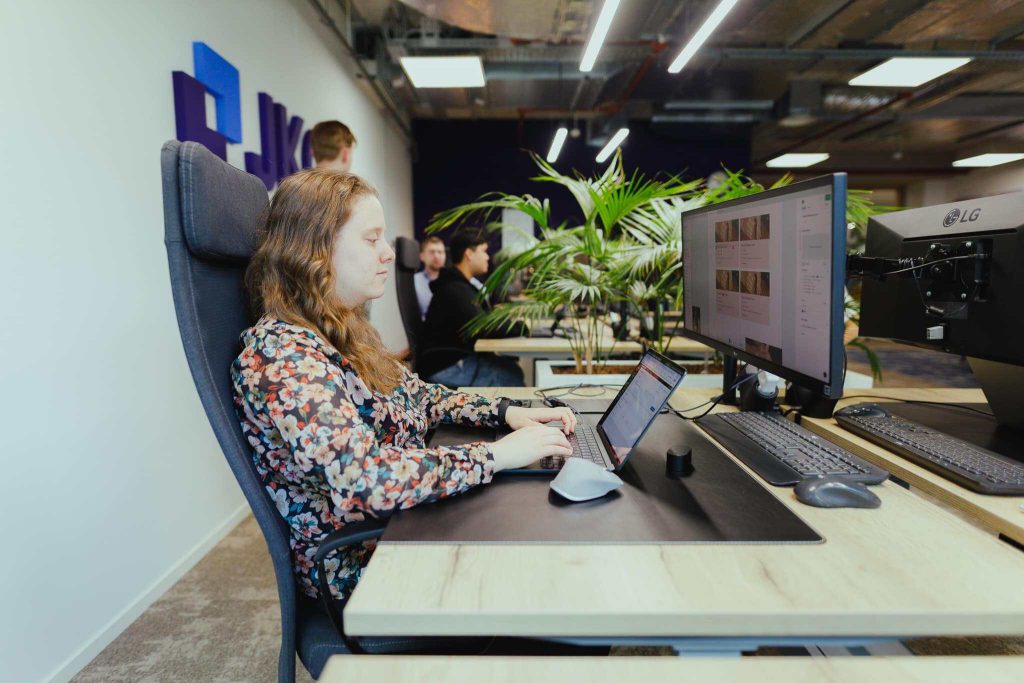 A colleague working on a web application behind two monitors