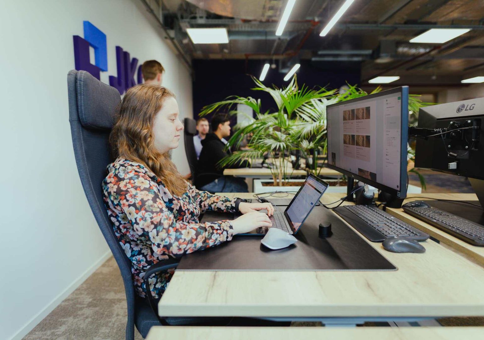 A colleague working on a web application behind two monitors