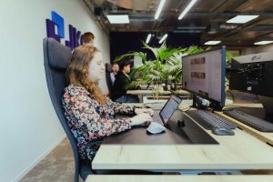 A colleague working on a web application behind two monitors