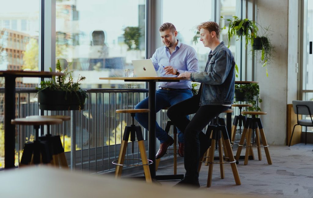 Twee collega's die samen een plan doornemen aan een statafel