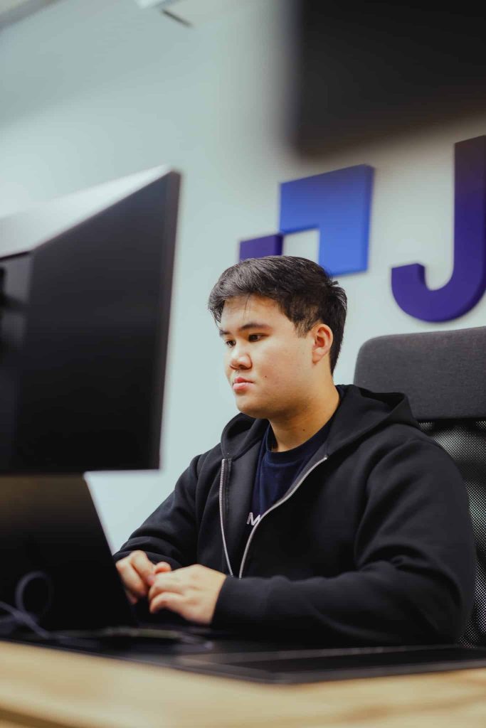 A colleague analysing a competitor site behind a monitor in the JKC office